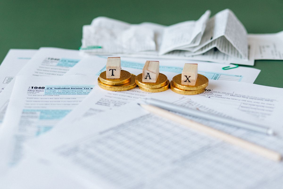 Tax blocks on stacked coins beside sales tax documents