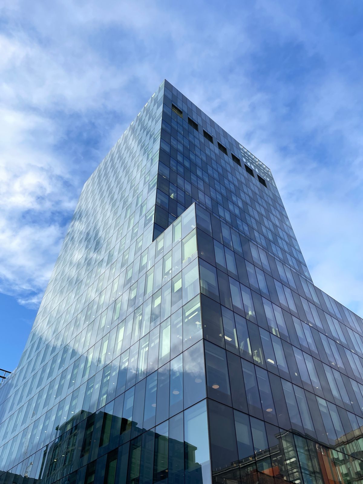 Modern corporate glass skyscraper against a blue sky